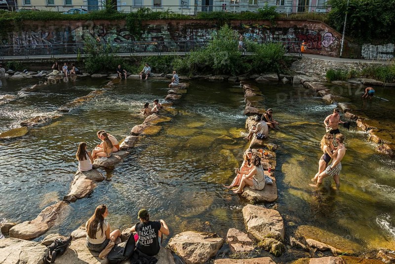 Young people sitting by and in the river, bathing in the city, heat, heat wave, climate change, Dreisam, Freiburg im Breisgau, Black Forest, Baden-Württemberg, southern Germany, Germany
