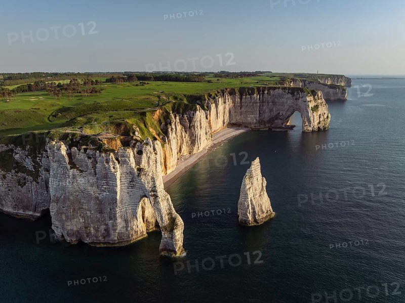 Aerial view of the Porte d'Aval rock formation in the evening sun, well-known sights on the chalk coast with the distinctive rock pin, behind it the La Manneporte rock formation and the Pointe de la Courtine ledge, then Pointe du Fourquet, right on the cliffs the Golf d'Étretat golf course founded in 1908, Alabaster Coast, La Côte d'Albâtre, chalk cliffs, English Channel, Seine-Maritime, Normandie, France