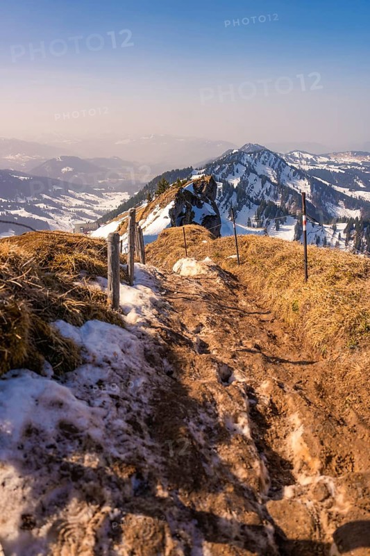 Snowy hiking trail on a mountain under clear, blue sky with distant views, Hochgrat Mountains, Allgäu, Bavaria, Germany