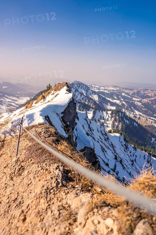 Rocky outcrop with snow-covered mountain panorama and clear blue sky, Hochgrat Mountains, Allgäu, Bavaria, Germany