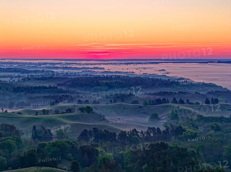 The hilly landscape of the Uckermark on the edge of the Oder Valley in morning light and fog above the Lower Oder Valley National Park. aerial view. Stützkow, Schwedt, Brandenburg, Germany