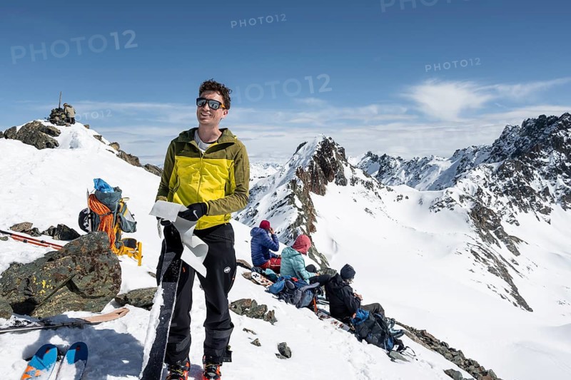 Ski tourers taking a break at the summit, on the Graubünden Haute Route, Scalettahorn, Snow-covered mountains, Winter in the Albula Alps, Graubünden, Switzerland