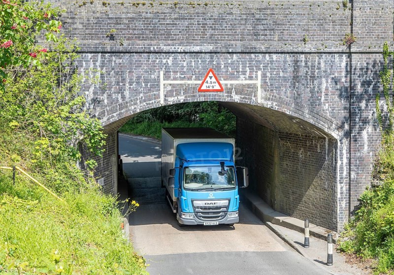 DAF truck lorry driving through low bridge, Pewsey, Wiltshire, England, UK