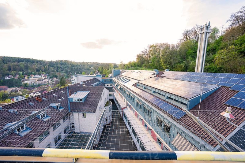 Hospital roof with solar panels surrounded by hilly landscape, old disused hospital, Calw, Germany