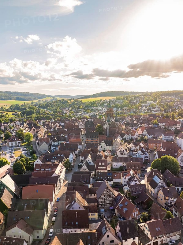 Sunset over a historic town with many rooftops and a striking church in a central location, Weil der Stadt, Germany