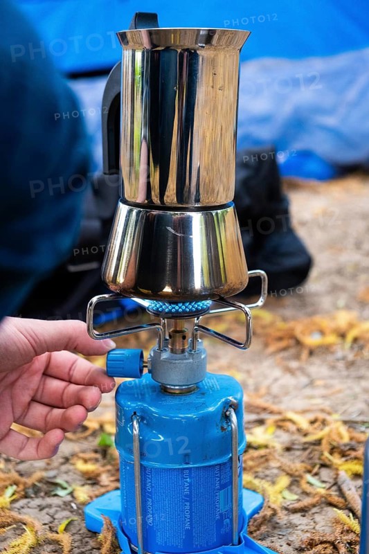 One person makes espresso on a camping cooker