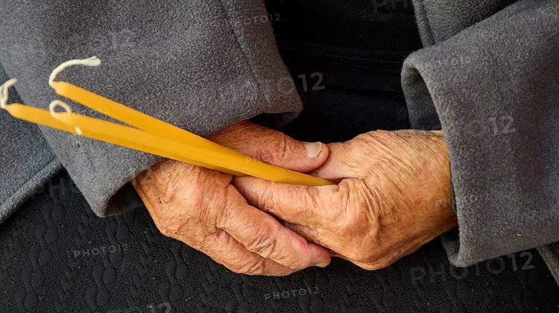 Elderly hands holding candles symbolising faith and tradition, Easter 2025, Church of the Dormition of the All-Holy God Bear, Kimisis tis Theotokou, Asklipio, Rhodes, Dodecanese, Greek Islands, Greece