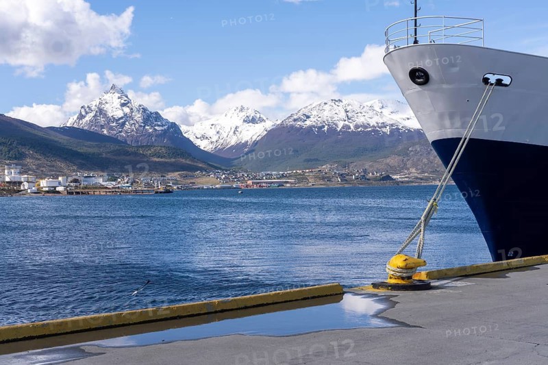 Bow of a ship moored at the wharf, in the background a city and snow-capped mountains on the Beagle Channel, Ushuaia harbour, Tierra del Fuego, Argentina