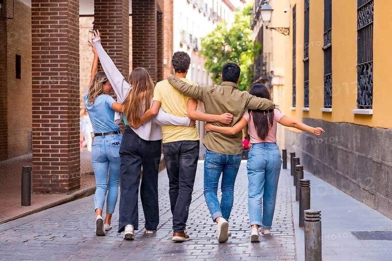 Group of multiracial friends hugging from behind in the city, friendship concept with boys and girls