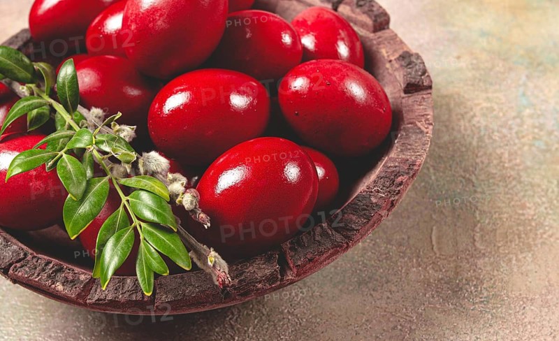 Painted eggs in a wooden bowl, red, painted madder dye, powder from the roots of endro, with onion husks, top view, Easter, Georgia