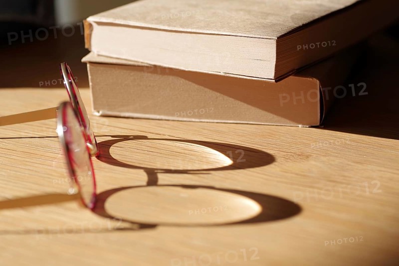 Symbol Reading, glasses, book, shadow, light, reflection, The shadow falls from the lens of a pair of glasses on a table. Two books lie in the background