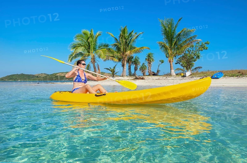 Woman sea kayaking in Fiji islands turquoise water, Waya island, Yasawa islands, Fiji