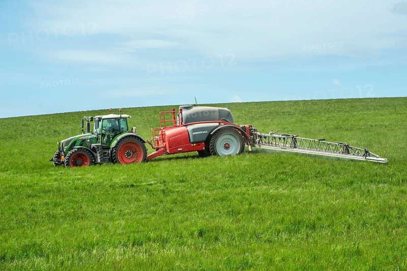 Spring farming, spreading fertilizer on a field with crops with a tractor in Ystad municipality, Skåne county, Sweden, Scandinavia