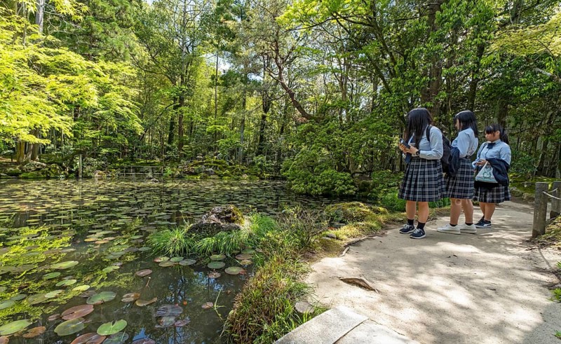 Japanese school children in uniforms visit the Tenjuan Garden, Nanzen-ji temple complex, Kyoto, Japan