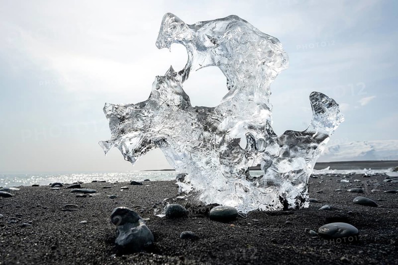 Ice, piece of ice with holes on the black sand beach, on the black lava beach Diamond Beach, southeast Iceland, Iceland