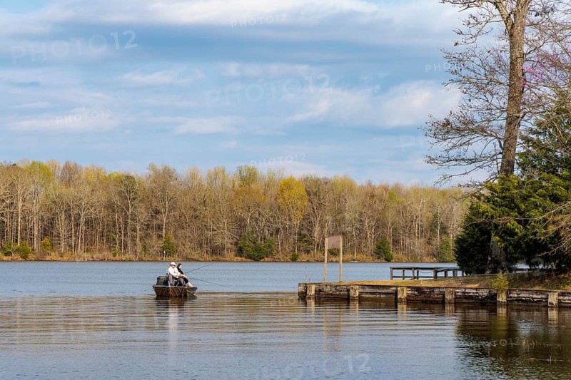 Couple fishing from a boat along the shore of Aberdeen Lake on the Tennessee-Tombigbee Waterway near Aberdeen, Mississippi