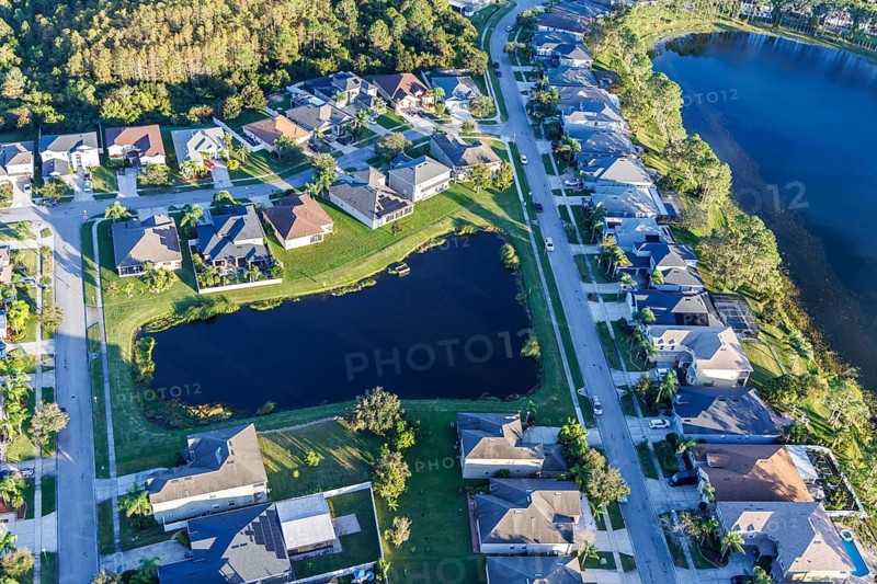 Aerial view of a new housing estate with houses on the lake in Wyndham Lakes, Orlando, USA