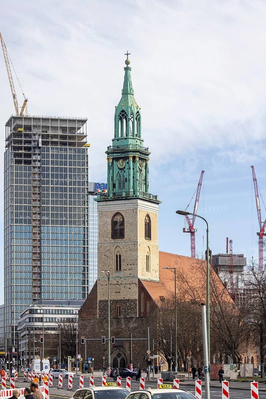 View of St. Mary's Church and The Berlinian construction site. When completed, the tower should be 146 meters high. On the right, the Covivio Tower construction site. Berlin, Germany