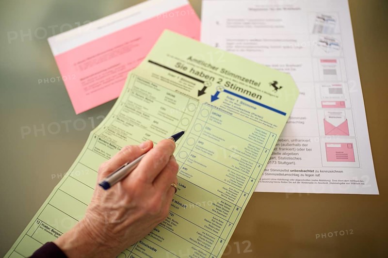 Voting, woman holding ballpoint pen, fills out ballot papers, votes, absentee ballot, official postal ballot documents, envelope, ballot envelope, instructions, election, parliamentary election, 2026 state election, Stuttgart, Baden-Württemberg, Germany