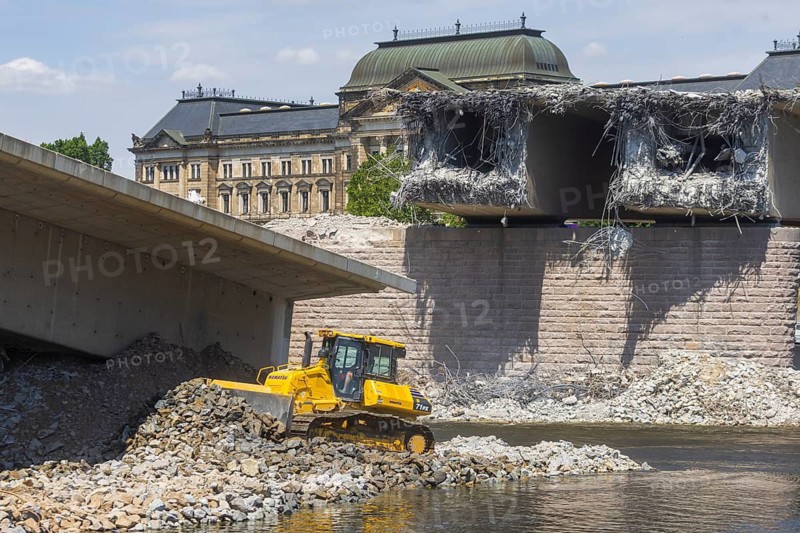 Demolition work continues following the partial collapse of the Carola Bridge. Construction of a road in the Elbe in preparation for further demolition work on the bridge. A caterpillar pushes river building blocks into the Elbe, Dresden, Saxony, Germany