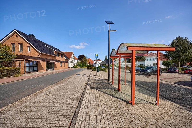 Bus stop Zetel Denkmal, bus shelter, residential building, blue sky, Dammstraße, Zetel, district of Friesland, Lower Saxony, Germany