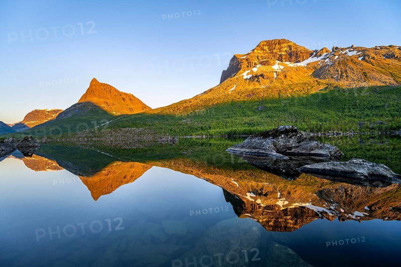 Picturesque mountain landscape in the Innerdalen high valley with Innerdalstårnet peak, mountain peaks reflected in Lake Innerdalsvatna, in the evening light at sunset, Trollheimen Mountain Area, Sunndal, Møre og Romsdal, Norway