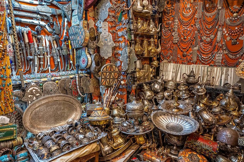 Brass plates, teapots knives and jewelry, necklaces on display in a shop for sale, Souk Bazaar, Maghreb, Marrakech, Morocco, North Africa