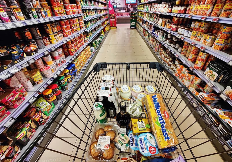 Shopping cart with goods is pushed through an aisle, supermarket, Germany