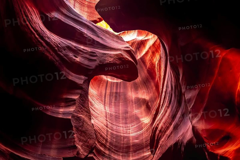 Antelope canyon slot formations exhibit vibrant orange and red sandstone walls, creating a stunning abstract natural landscape with light beams highlighting the smooth, wave like textures