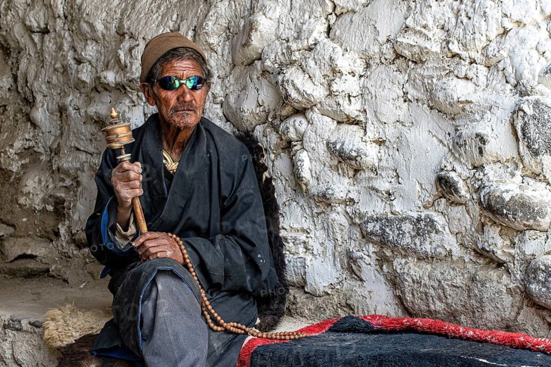 Elderly man wearing Buddhist stone mill and prayer necklace, Mala, in traditional dress, wearing modern sunglasses, Lo Manthang, Mustang, Upper Mustang, former kingdom, Himalayas, Nepal