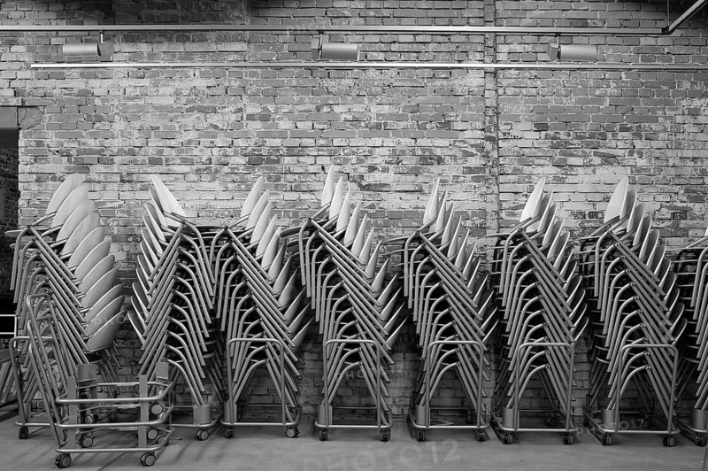 Modern stacking chairs in front of a brick wall, unfinished small hall of the NS Congress Hall from 1943, today Reichsparteitagsgelände Documentation Center, black and white, Bayernstraße 110, Nuremberg, Middle Franconia, Bavaria, Germany
