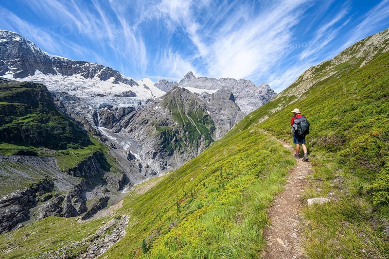 Mountaineers on hiking trail in front of mountain panorama, picturesque high alpine mountain landscape with Grindelwald-Fiescherfirn glacier, hike to Schreckhornhütte, Bernese Oberland, Switzerland