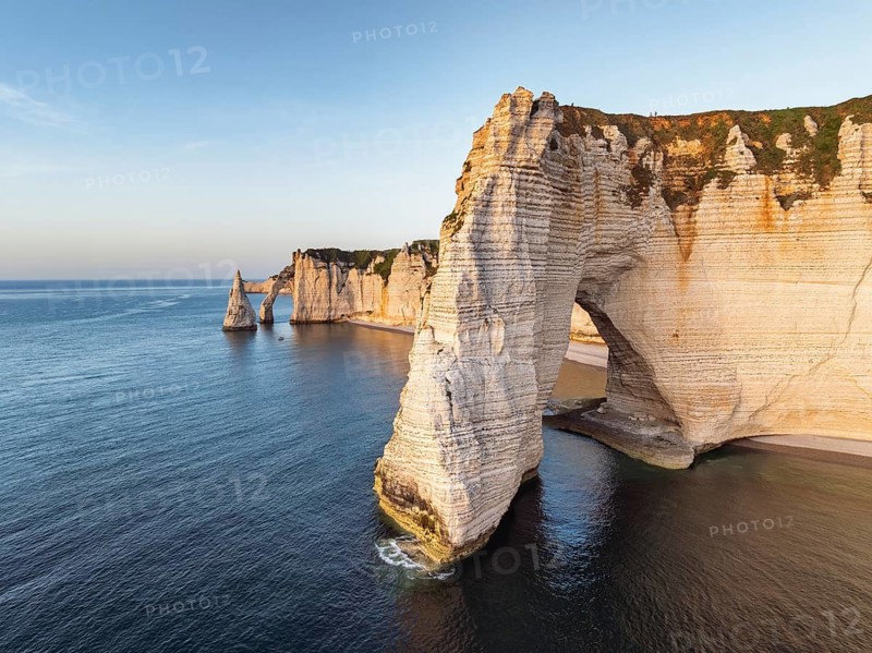 Aerial view of La Manneporte rock gate in the evening sun, behind it the Porte d'Aval rock formation, well-known sights on the chalk coast with the distinctive rock pin, Alabaster Coast, La Côte d'Albâtre, chalk cliffs, English Channel, Seine-Maritime, Normandy, France