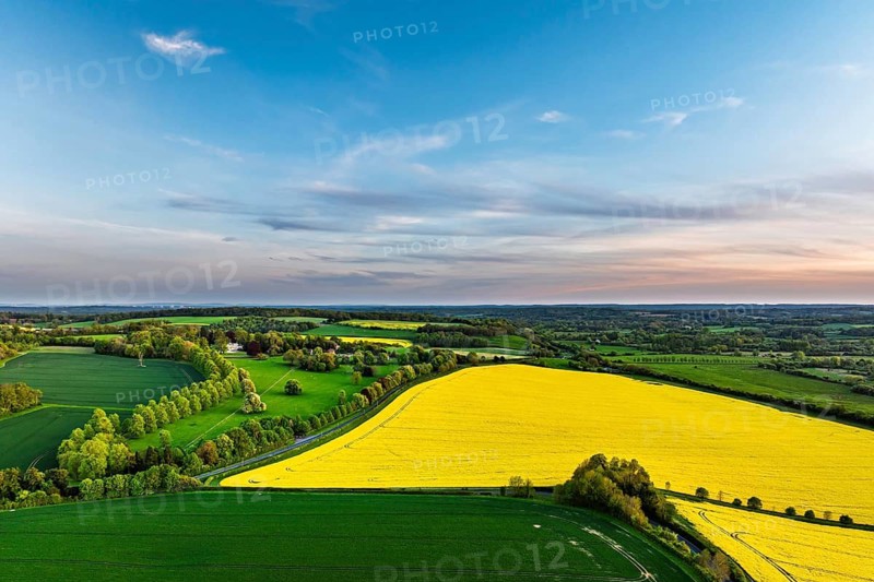Sunset of Rapeseed Fields and Farms over Horsebridge nad Stockbridge from a drone, Hampshire, England, United Kingdom