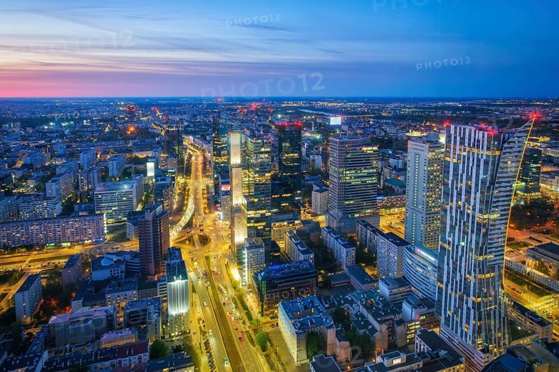 Cityscape view of the Warsaw skyline in Poland with skyscrapers, city lights, traffic trails, blue hour twilight and evening glow