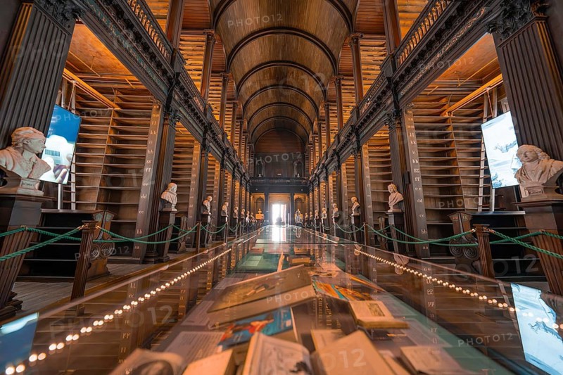 Impressive library with a long display case full of books and soft lighting, Trinity Collage, Dublin, Ireland