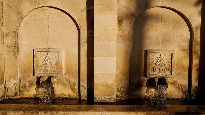 Two ancient stone wall fountains with running water in the evening sun, Meronas village, Meronas, Amari Basin, Central Crete, Greek Islands, Greece
