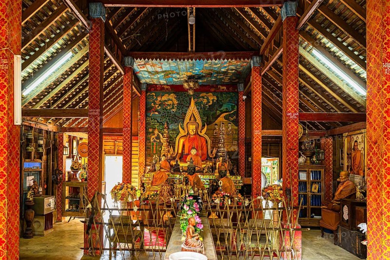 Buddhist temple, artfully designed interior with Buddha statue and offerings, Mae Kampong Village, Chiang Mai Province, Thailand
