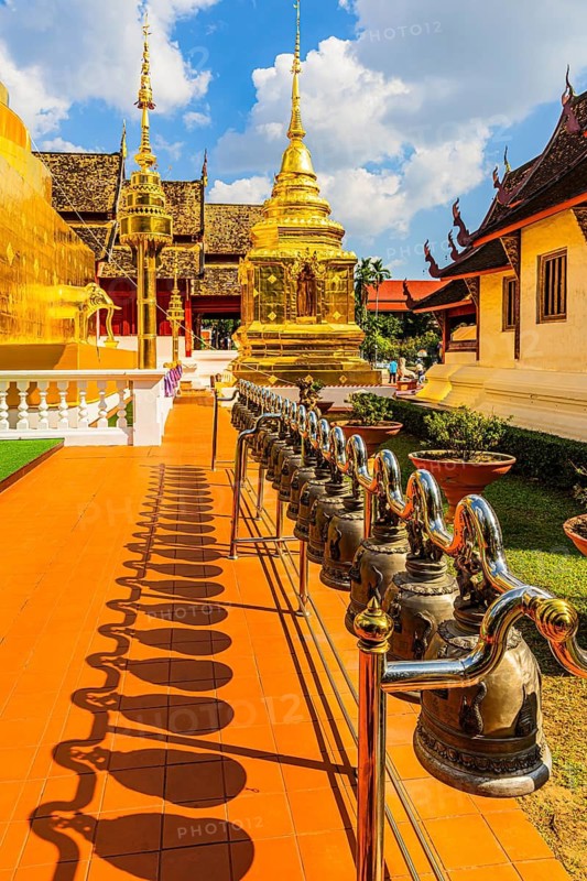 Prayer bells, hung in a row, gilded temple towers at the back, chedi, stupas in the Wat Phra Singh Buddhist temple complex, Chiang Mai Old City Center, Chiang Mai Province, Thailand