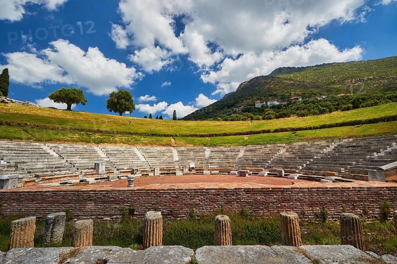 View of an ancient amphitheatre surrounded by green nature under blue sky, Theatre of Messene, Ancient Site, Archaeological Site, Messene, Messini, Messinia, Southwest of the Peloponnese, Odyssey, Odyssey, Odysseus, Ulysses, Film, Filming Location, Matt Damon, Peloponnese, Peninsula, Greece