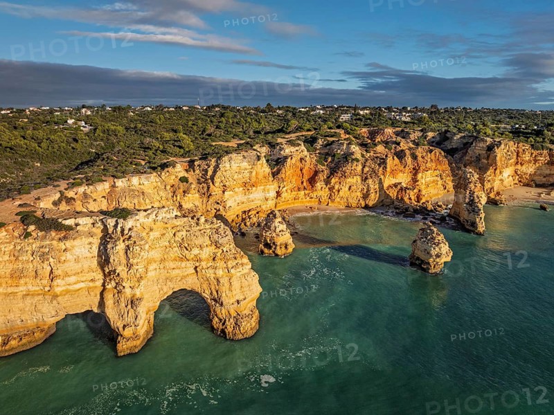 Aerial view of Praia da Marinha beach in Algarve, Portugal, with ocean cliffs, sea stacks and clear Atlantic water