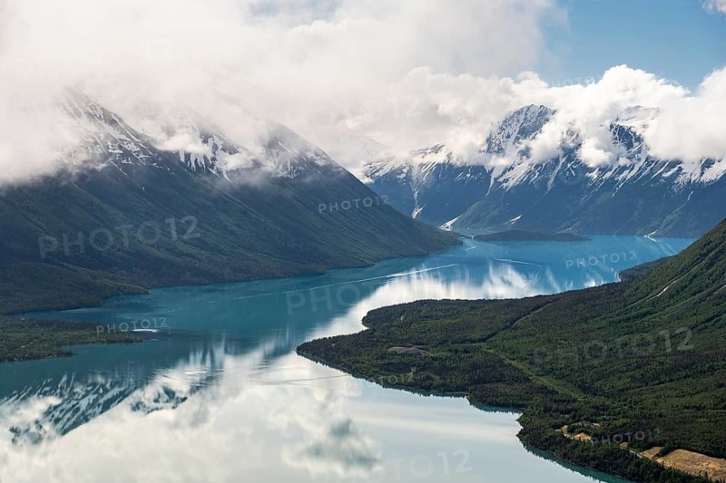 View of snowy mountains in spring and turquoise Kenai Lake with reflection, Slaughter Ridge Trail, Cooper Landing, Kenai Peninsula, Alaska, USA
