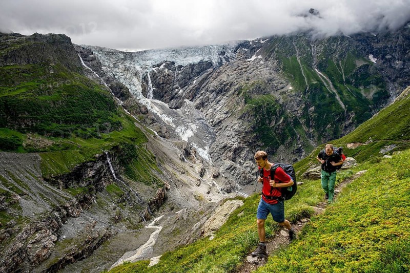 Mountaineers on a hiking trail, dramatic mountain landscape with Grindelwald-Fiescherfirn glacier, Bernese Alps, Bernese Oberland, Switzerland