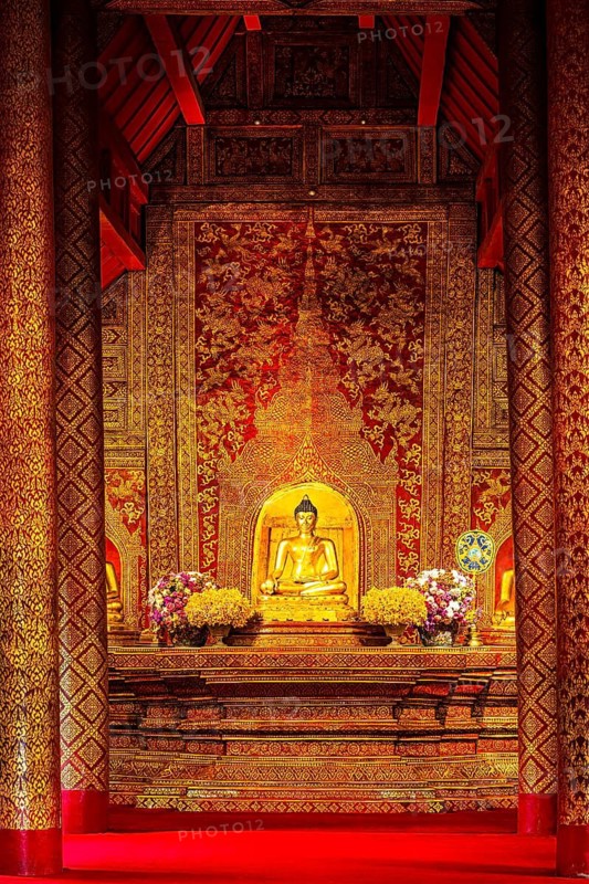 Gilded seated Buddha statue in a public prayer hall in the Wat Phra Singh Buddhist temple complex, Chiang Mai Old City Center, Chiang Mai Province, Thailand