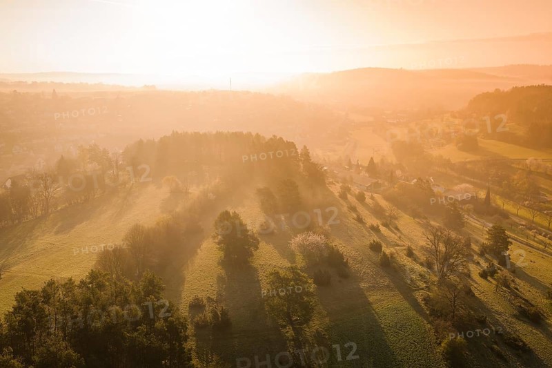 Hilly landscape with sunset and long shadows over meadows, Deufringen, Aidlingen, Heckengäu region, Böblingen district, Germany