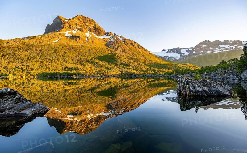 Picturesque mountain landscape in the Innerdalen high valley, mountain peaks reflected in Lake Innerdalsvatna, in the evening light at sunset, Trollheimen Mountain Area, Sunndal, Møre og Romsdal, Norway