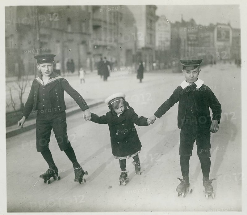 Berlin, roller skating, children, girls, boys, leisure, fun, middle class, Three children on roller skates holding hands and skating in the street, Philipp Kester, around 1906