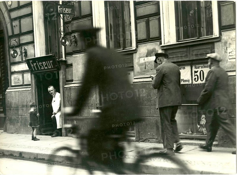 Berlin, Mitte, Grenadierstr., Scheunenviertel, Jewish shops, twenties, Eastern Jews, A barber shop in a busy street with passers-by and a cyclist, Sasha Stone, around 1928