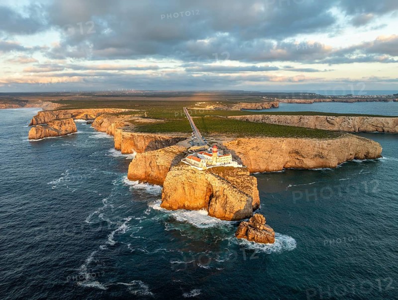 Drone view of the Lighthouse of Cabo de Sao Vicente in Sagres, Algarve, Portugal, at sunset with darkening sky and Atlantic ocean