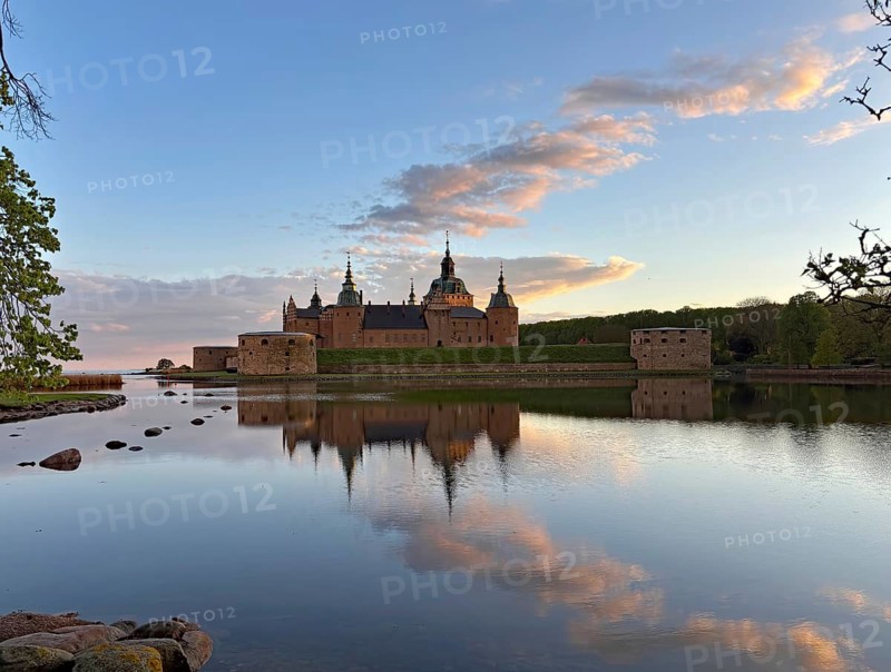 Fairytale castle with reflection in calm water, surrounded by nature and evening sky, Kalmar Slott, Kalmar Län, Sweden